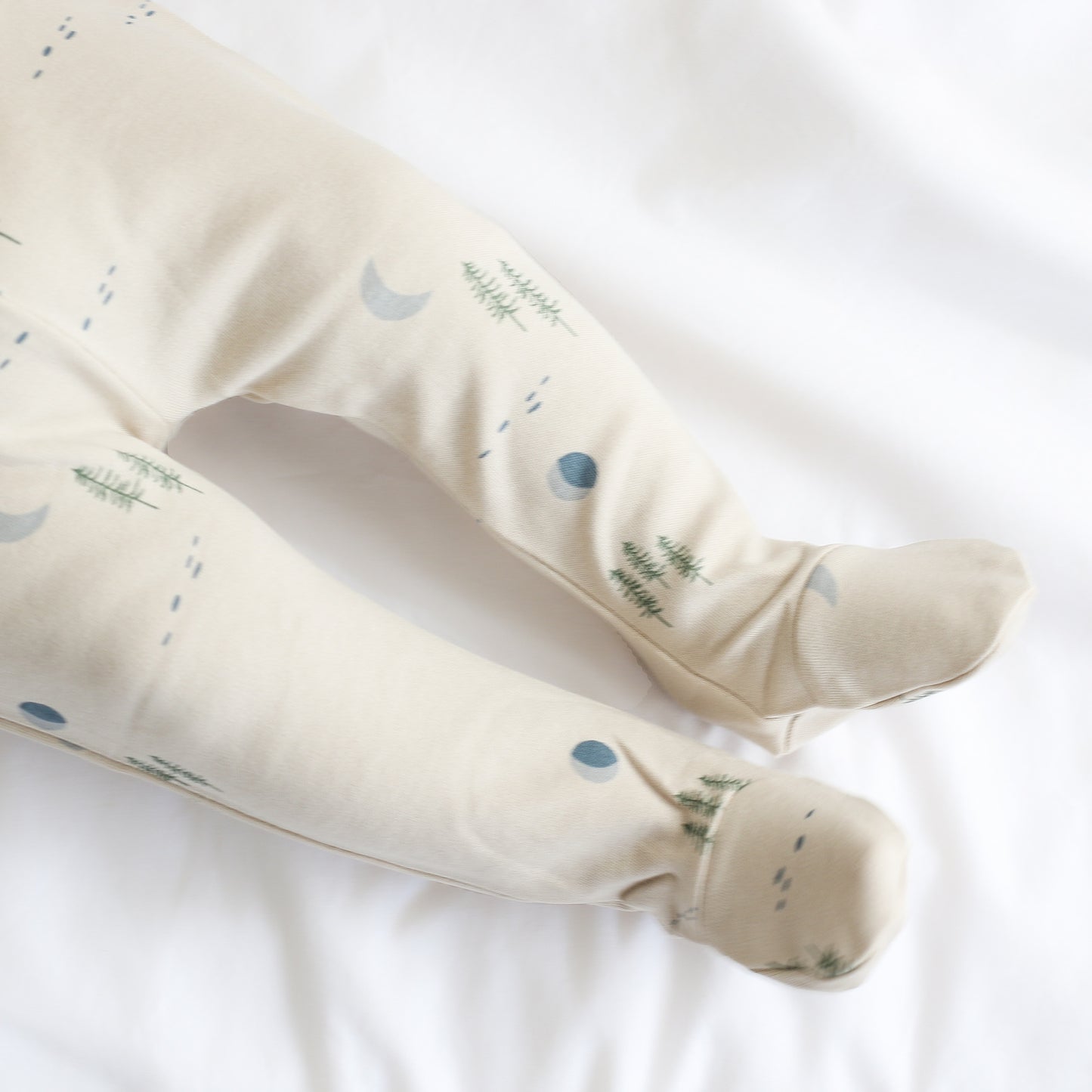 Close up shot of Baby wearing Midnight Forest Footed Pants, designed by Burrow and Be