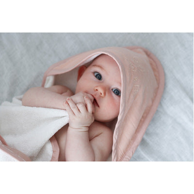 Baby wrapped in Dusty Rose Essential Baby Hooded Towel designed by Burrow and Be