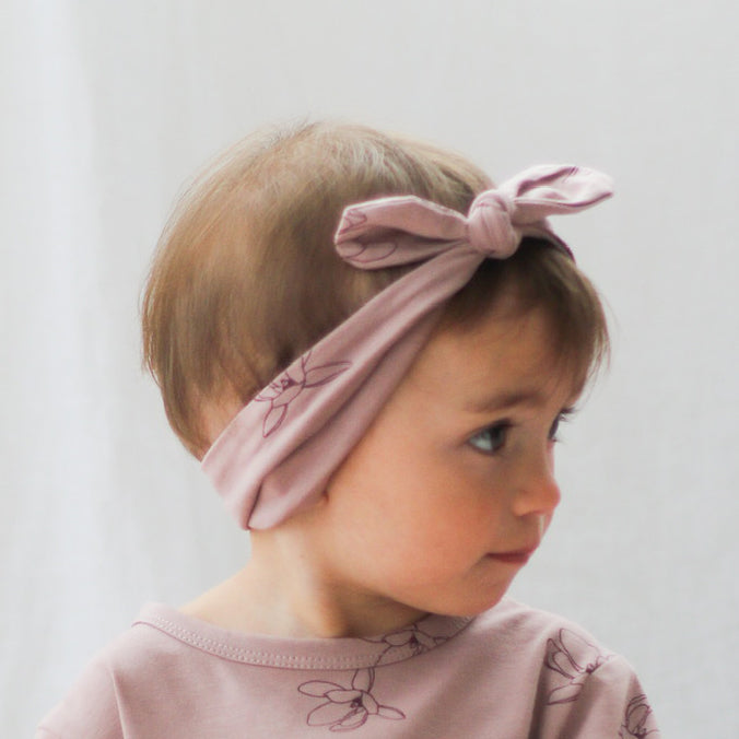 Baby girl wearing T-shirt and Essential Baby Headband both in Magnolia print, designed by Burrow and Be