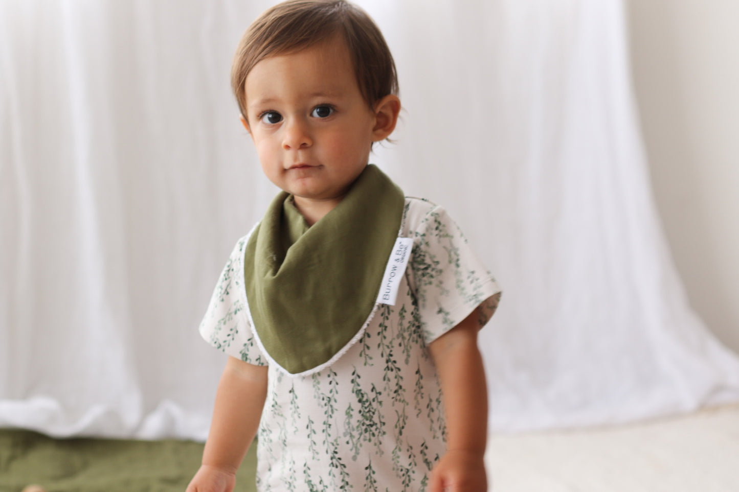 Toddler wearing Pine Dribble Bib and String of Pearls Alex Romper from Burrow and Be