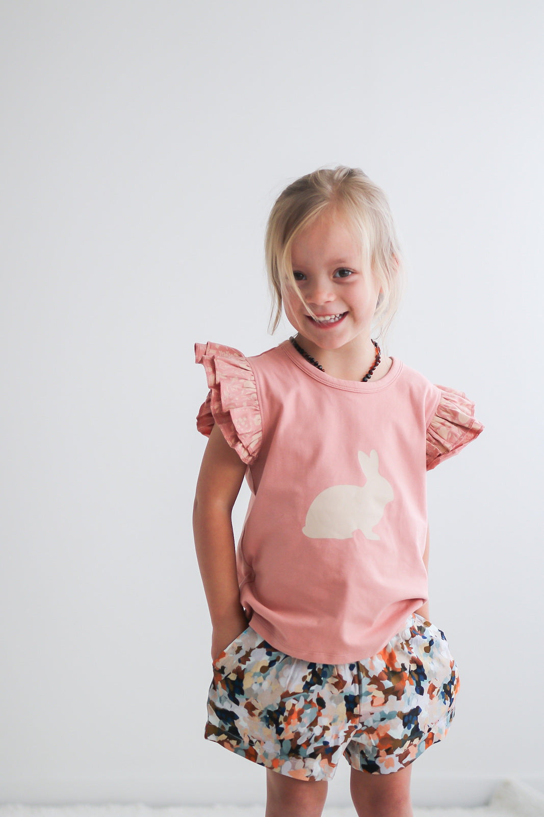 Girl posing at camera while wearing Doe flutter T-shirt and Delight Lyla Shorts by Burrow and Be
