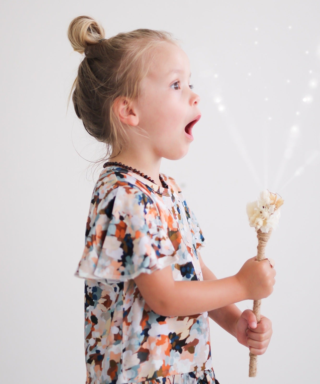 Girl wearing Delight Ella Top by Burrow and Be while holding Wand with Ribbon