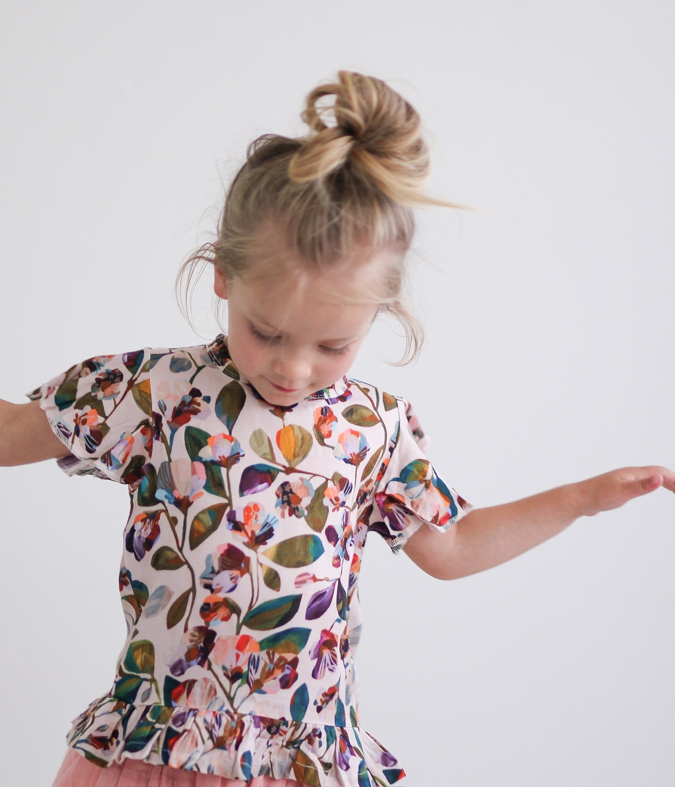 Child on white background with bunned up hair wearing Garden Party Ella Top by Burrow and Be