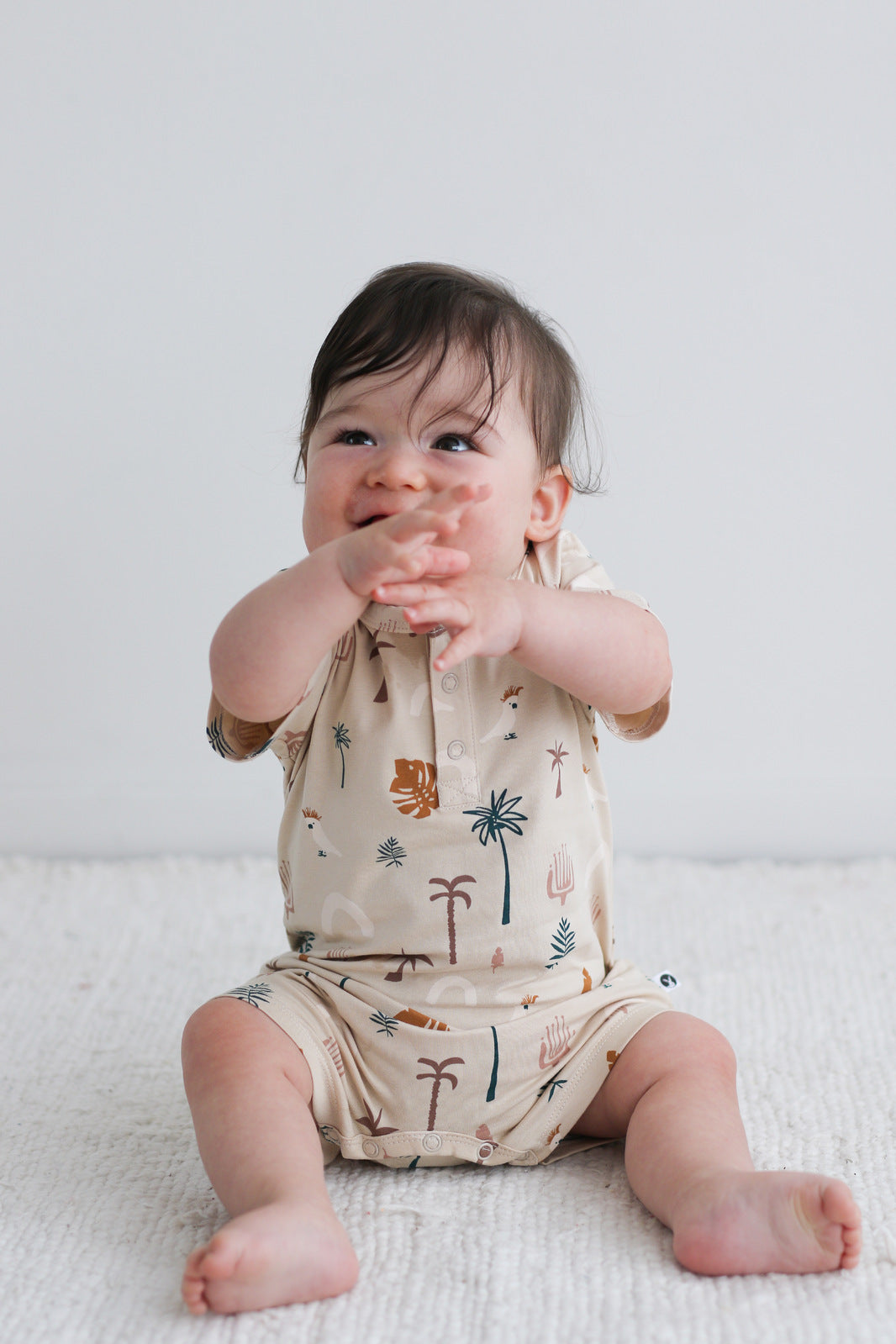 Baby crossing arms and wearing ungle Stamp Alex Romper from Burrow and Be