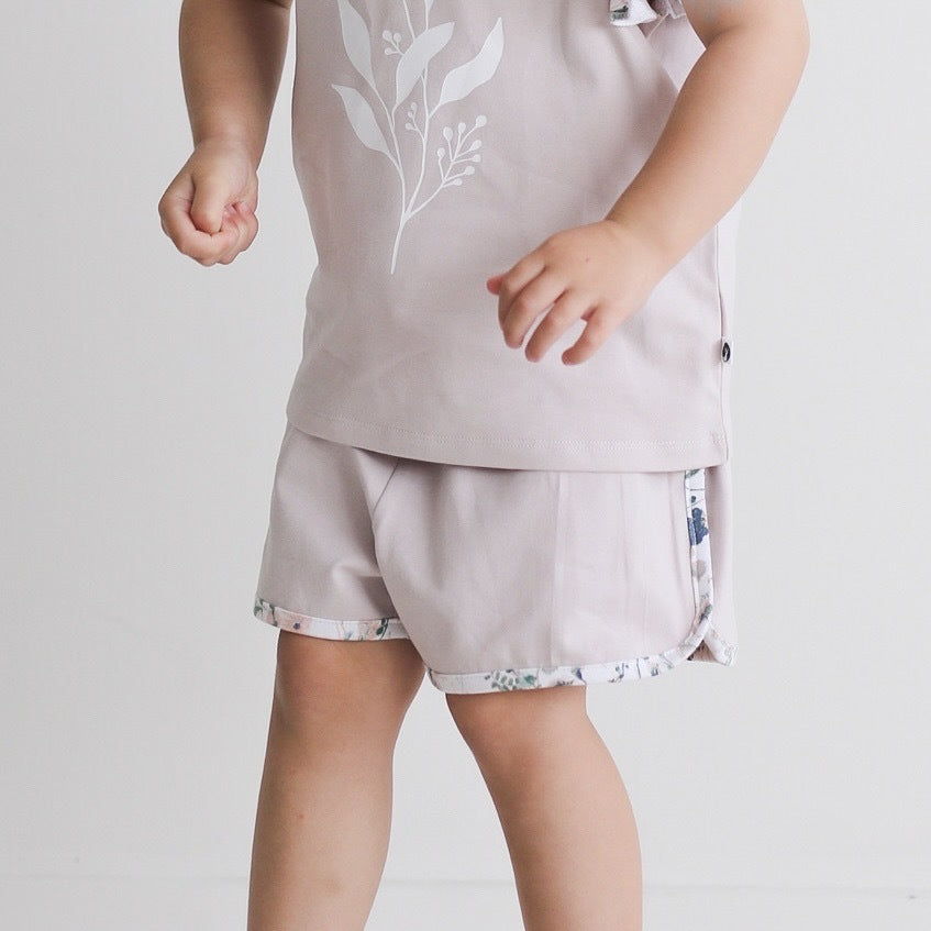 Child wearing Wildflower/Lavender Penny Shorts and Flutter T-shirt from Burrow and Be