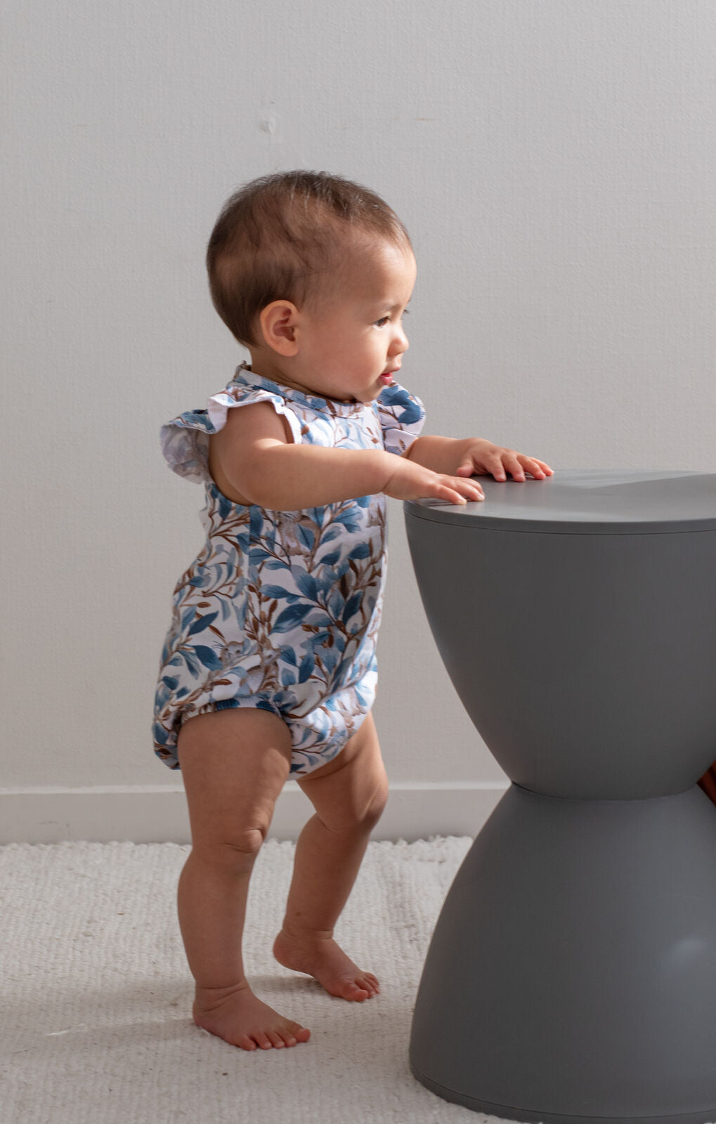 Baby wearing Eden Flutter Bubble Romper by Burrow and Be