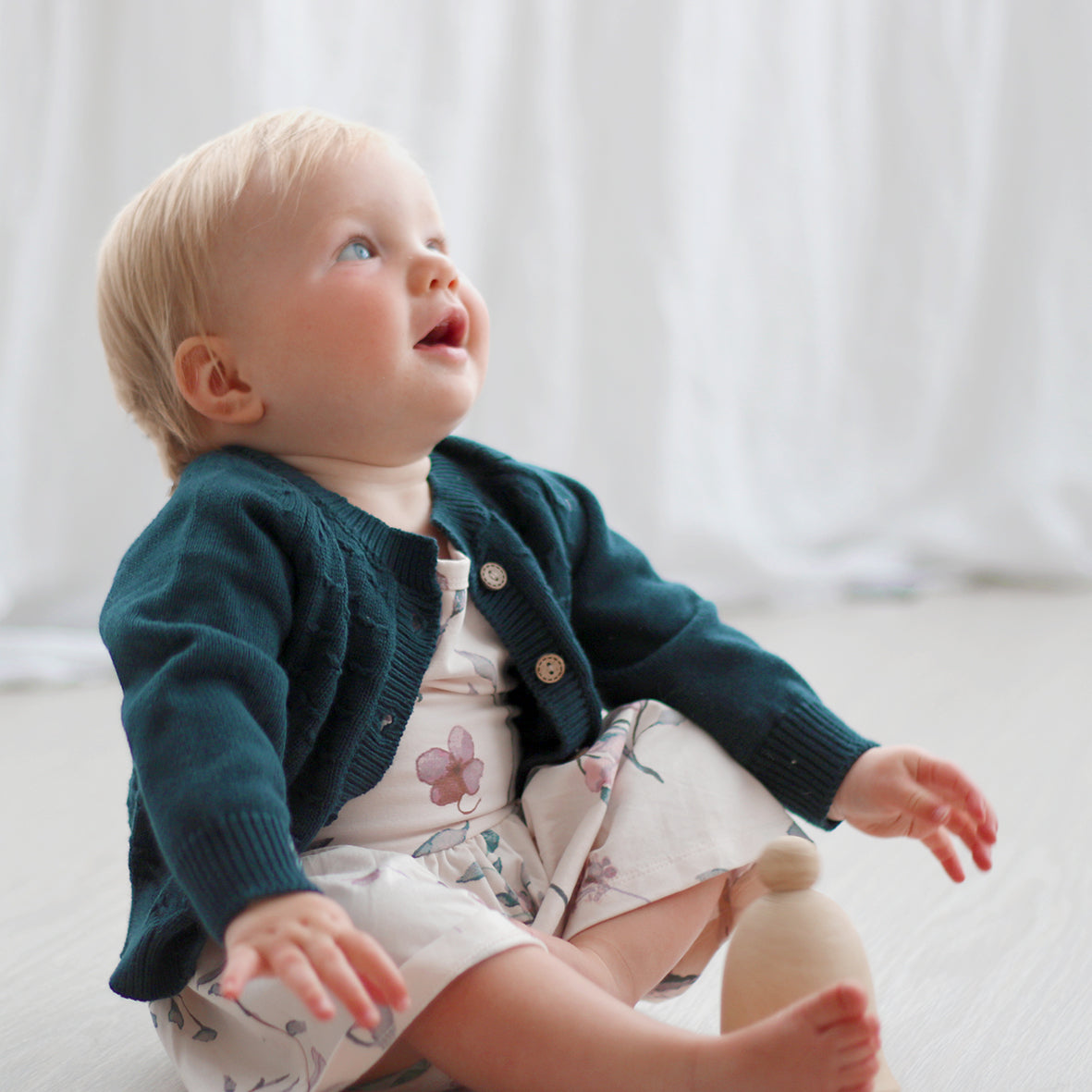 Baby wearing a Pink Flower Dress and Billie Knit Cardigan by Burrow and Be