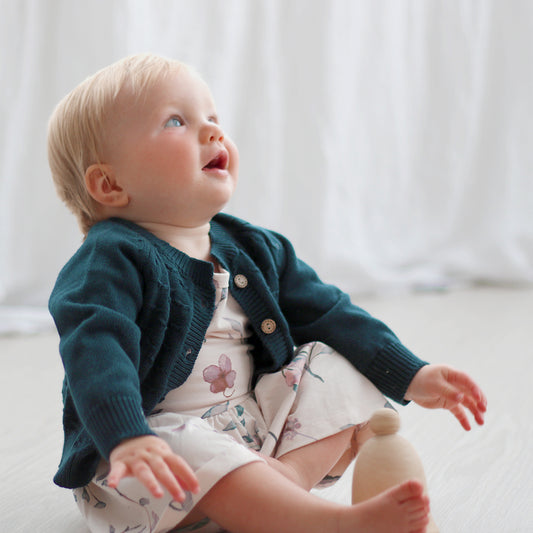 Baby wearing a Pink Flower Dress and Billie Knit Cardigan by Burrow and Be