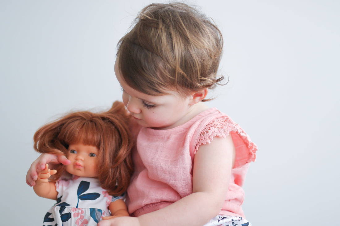 Baby caring for her doll