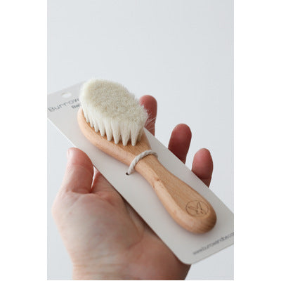 Hand holding Beech Wood and Goat Hair Baby Brush from Burrow and Be