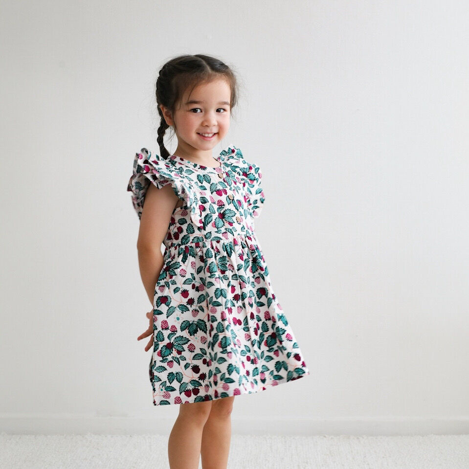 Young girl wearing a floral dress against a plain background