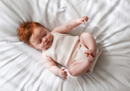 Newborn baby lying on a white bed