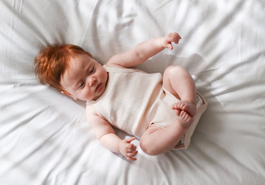 Newborn baby lying on a white bed