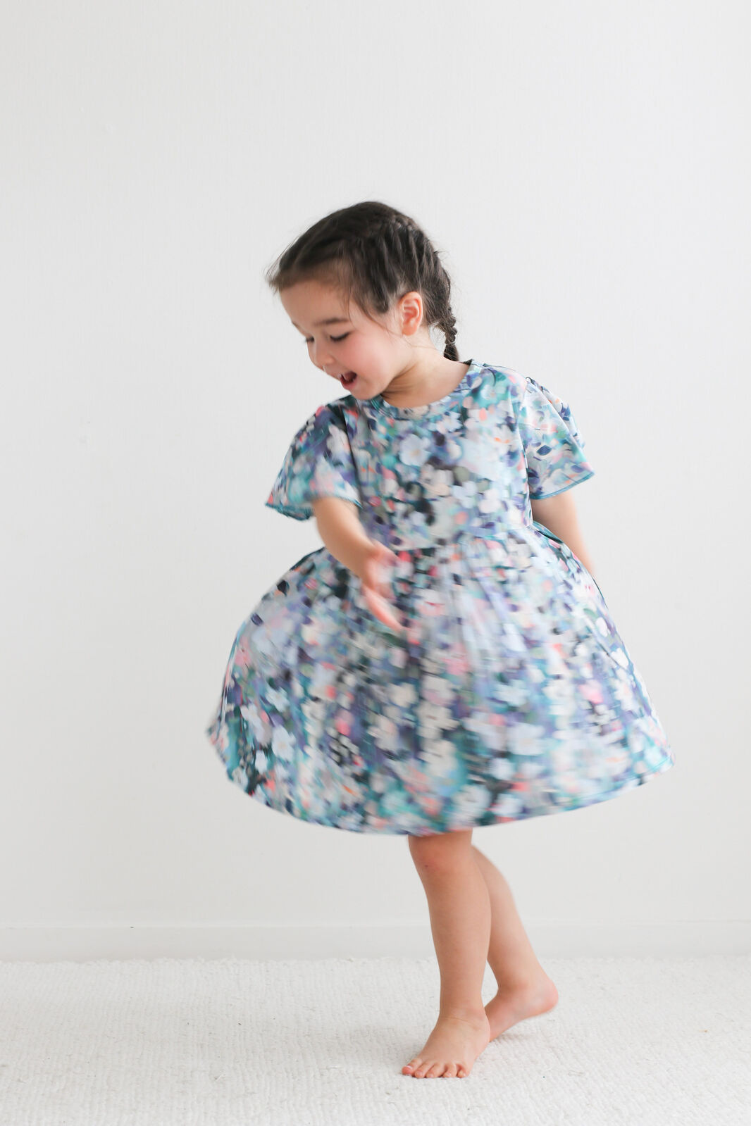 Child wearing a floral dress on a white background