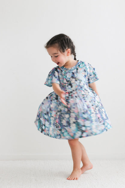 Child wearing a floral dress on a white background