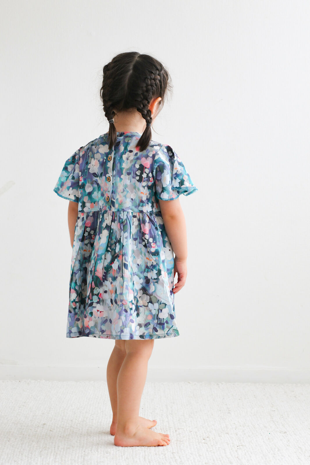 Child wearing a floral dress on a white background