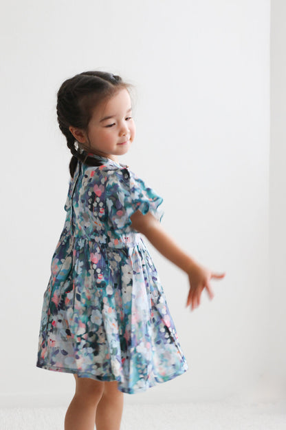 Young girl wearing a floral dress against a white background