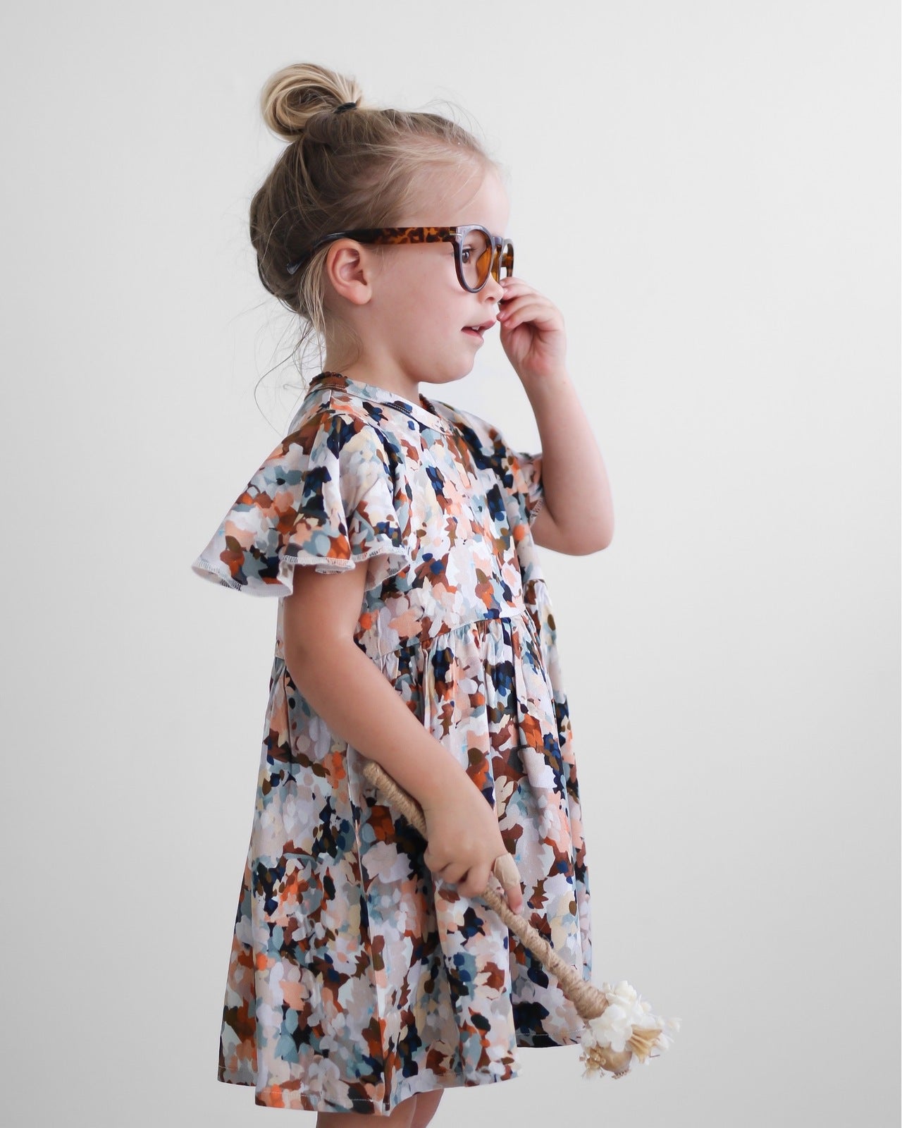 Girl wearing glasses and wand while wearing Delight Ella Dress by Burrow and Be