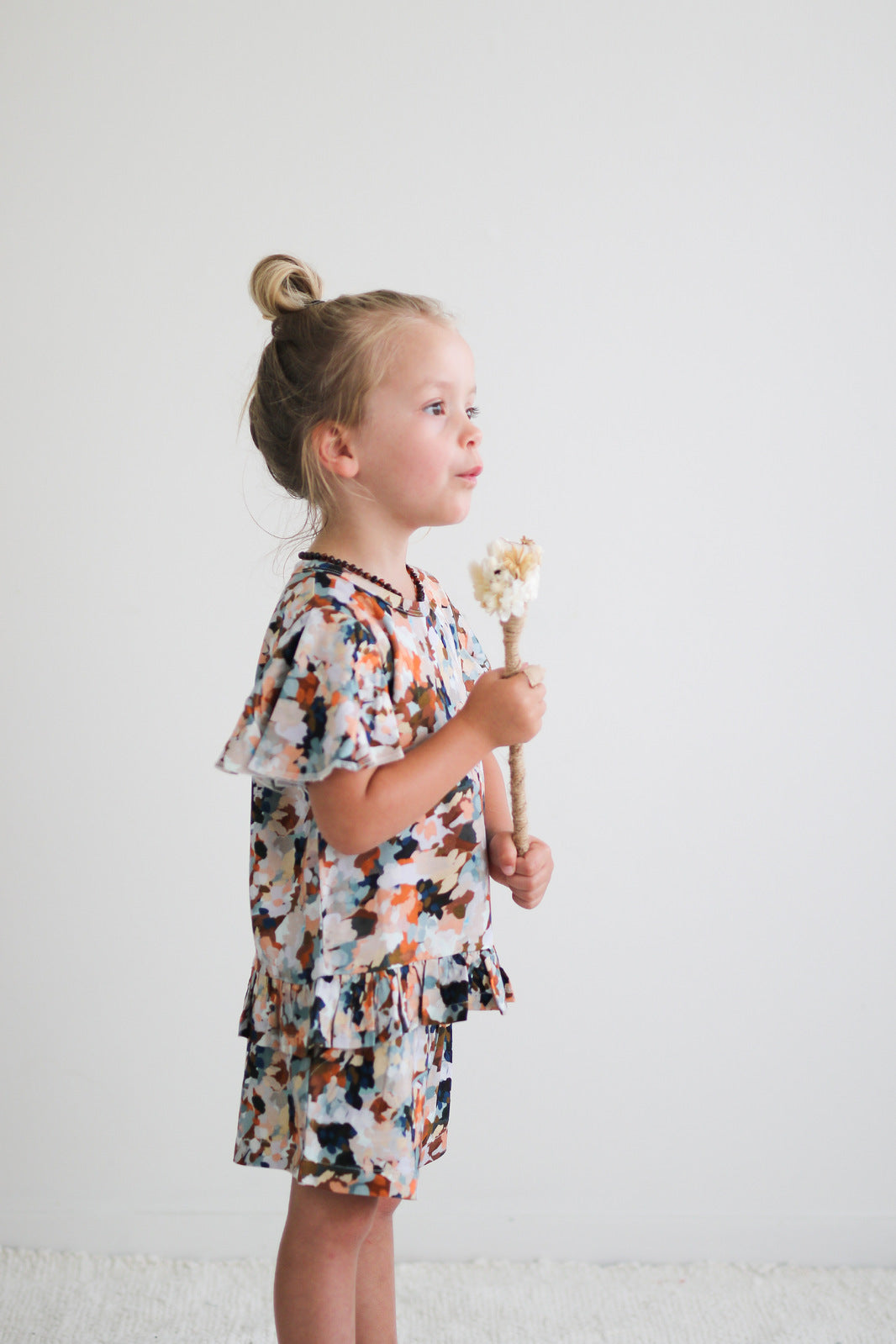 Girl blowing bubbles from want Delight Ella Top by Burrow and Be