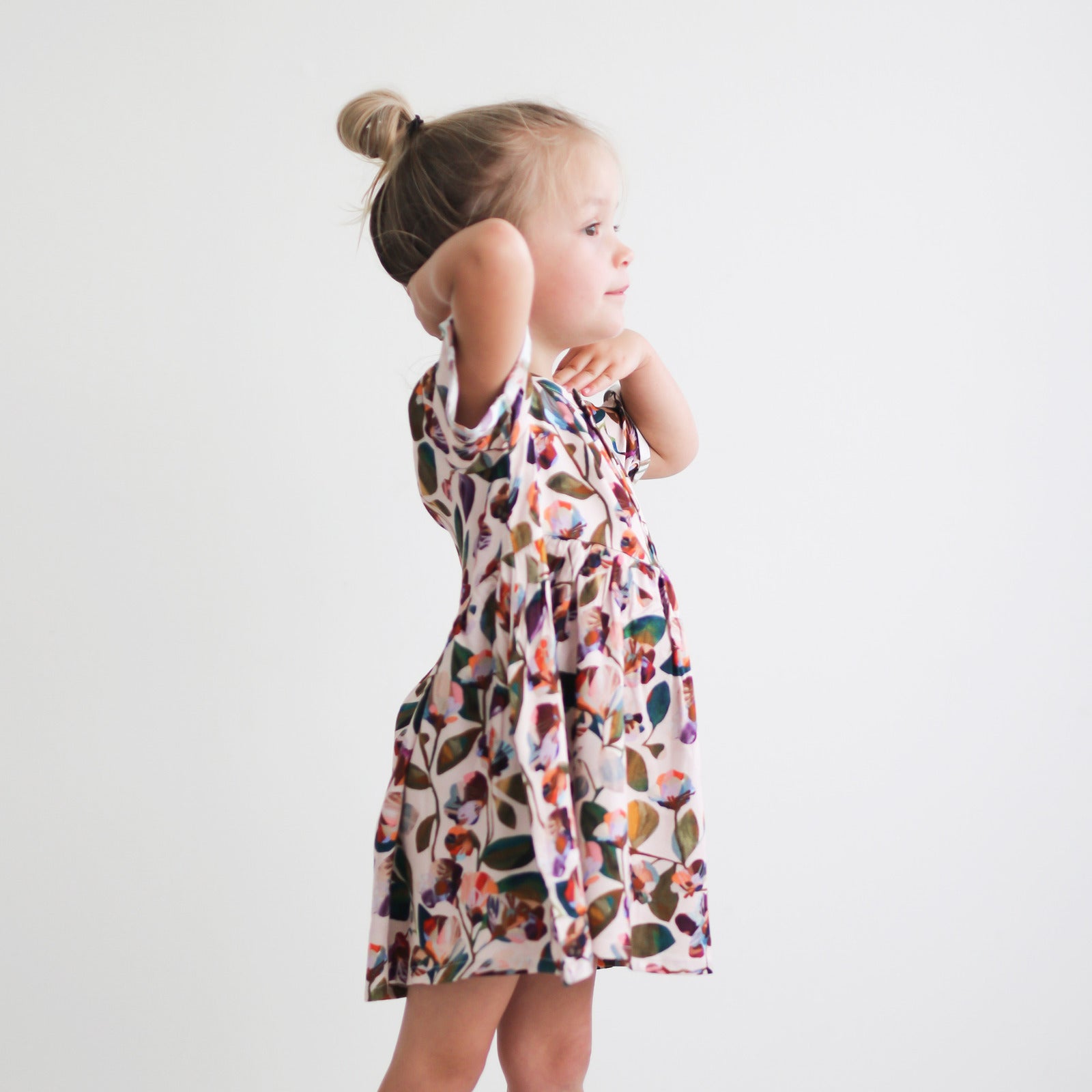 Girl staring into the distance against a white background while wearing Garden Party Mila Dress by Burrow and Be