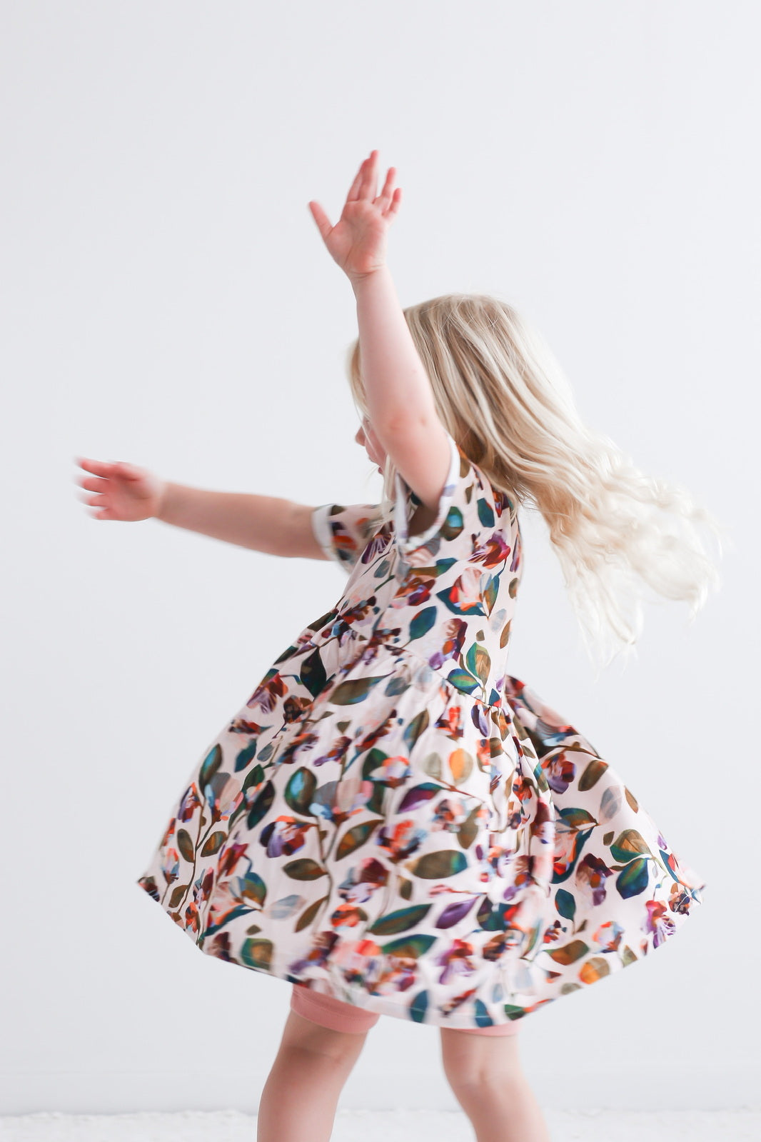 Girl wearing Garden Party Mila Dress by Burrow and Be and turning with flair
