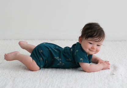 Baby lying on the floor with feet up while wearing Palm Alex Romper from Burrow and Be