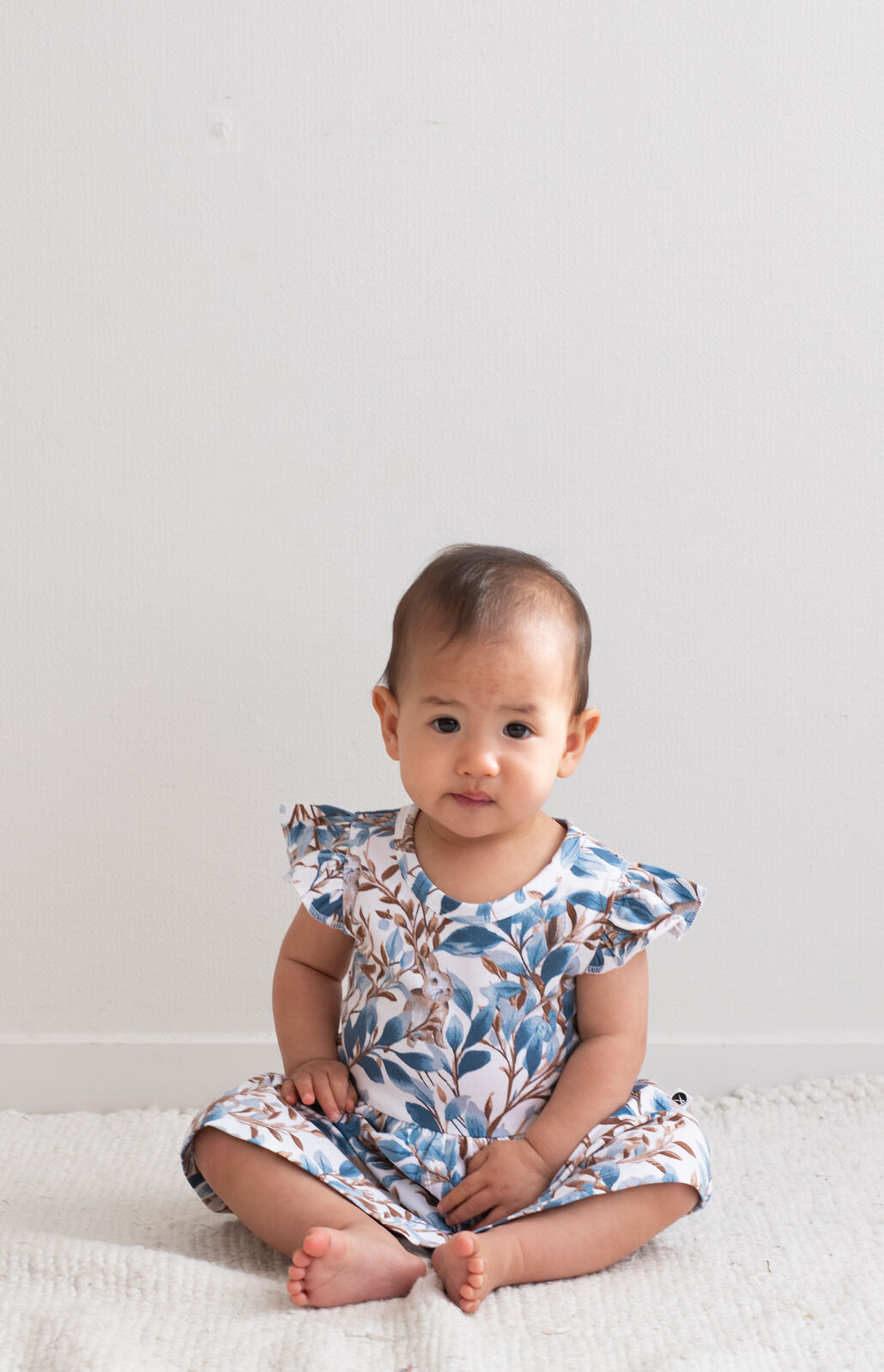 Baby wearing Eden Flutter Baby Dress by Burrow and Be