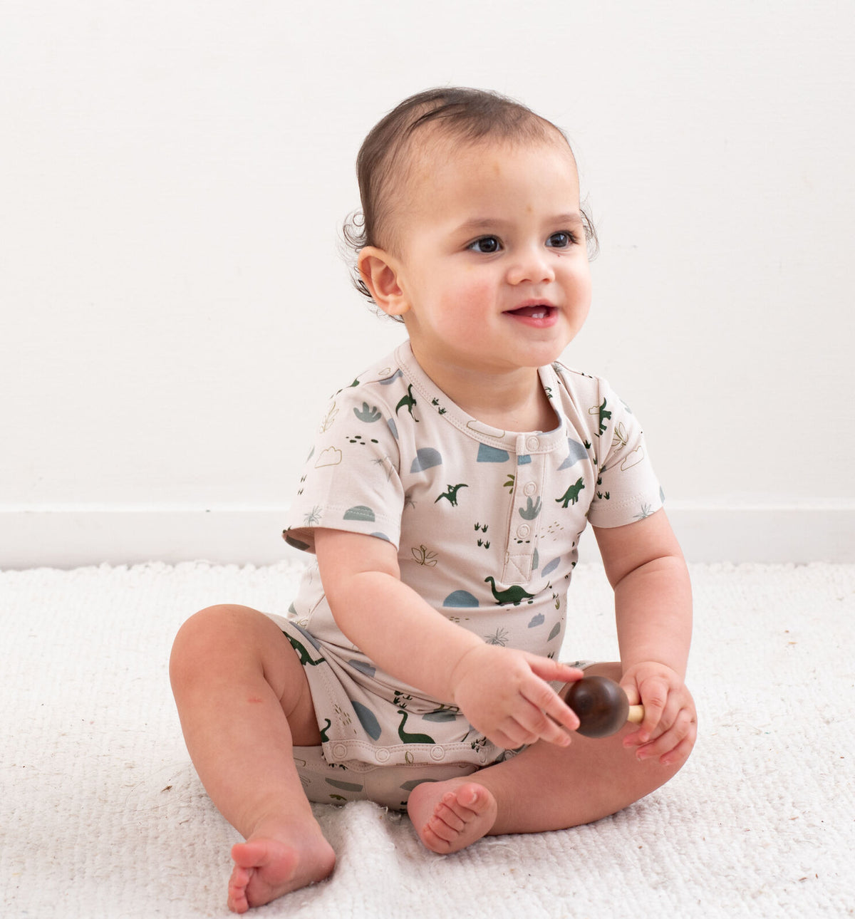 Jurassic Roam Alex Romper by Burrow and Be featuring earthy dinosaur print