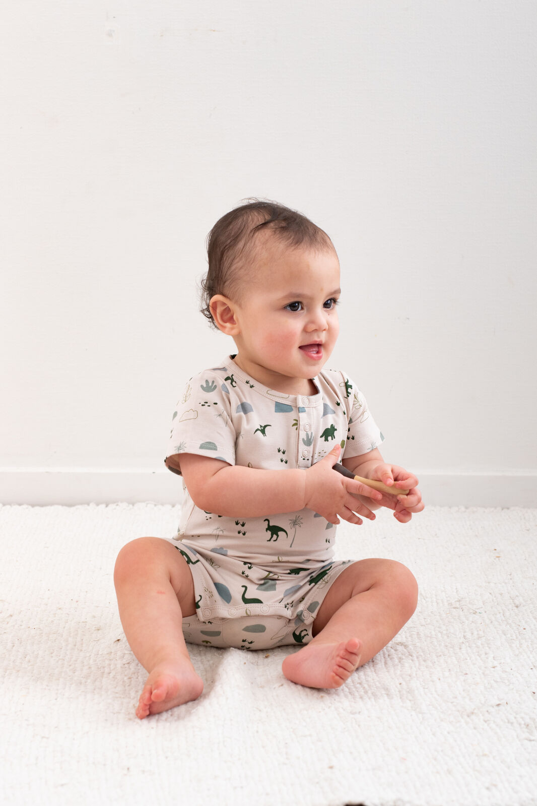Baby wearing Jurassic Roam Alex Romper by Burrow and Be